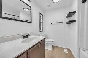 Full bathroom with shower / bathtub combination, toilet, vanity, and hardwood / wood-style flooring