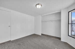 Unfurnished bedroom with carpet and a closet