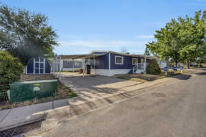 Manufactured / mobile home featuring a storage shed and a carport