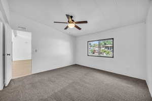 Carpeted empty room featuring ceiling fan