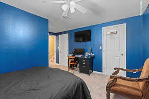 Carpeted bedroom featuring ceiling fan