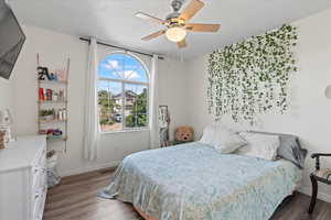 Bedroom with hardwood / wood-style floors and ceiling fan