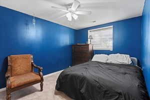 Carpeted bedroom featuring ceiling fan