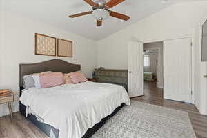 Bedroom featuring ceiling fan, lofted ceiling, and hardwood / wood-style floors