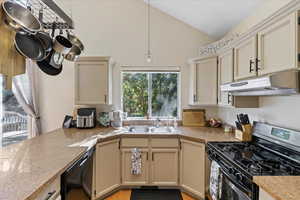 Kitchen featuring sink, black appliances, light hardwood / wood-style floors, and cream cabinetry