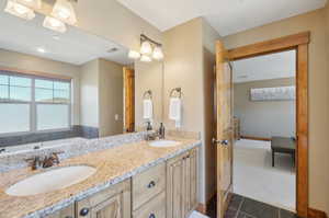 Bathroom featuring vanity, a tub, and tile patterned floors