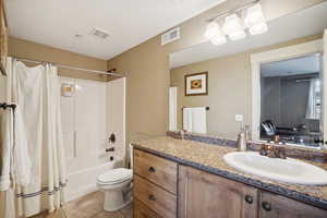 Full bathroom with vanity, toilet, shower / tub combo with curtain, and tile patterned flooring