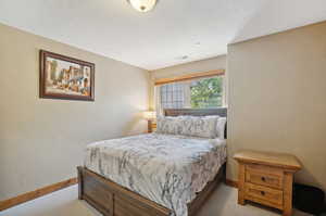 Bedroom featuring a textured ceiling and carpet flooring