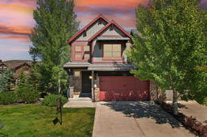 View of front of home featuring a garage and a lawn