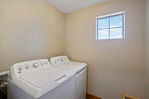 Laundry area featuring a textured ceiling and washer and dryer