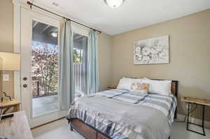 Bedroom featuring light carpet and access to outside