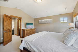 Carpeted bedroom with lofted ceiling