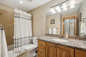 Full bathroom with vanity, toilet, shower / tub combo, and tile patterned floors