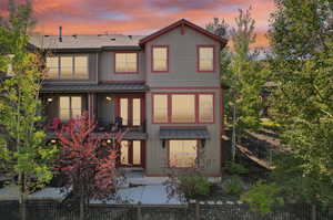 Back house at dusk featuring a balcony