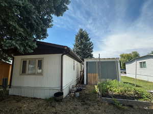 View of property exterior with a storage unit