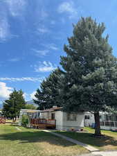 View of front of house with a front lawn and a wooden deck