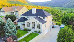 View of front facade with a front yard, a mountain view, and a garage