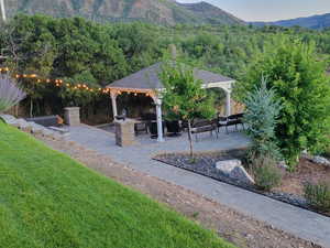 Exterior space with a lawn, a mountain view, a patio, and a gazebo