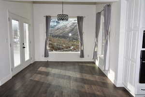 Unfurnished dining area with dark hardwood / wood-style flooring and french doors