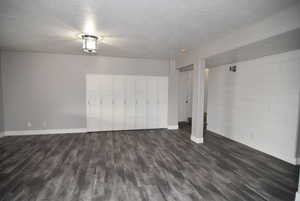 Interior space featuring dark hardwood / wood-style flooring and a textured ceiling