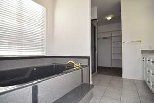 Bathroom featuring tile patterned floors, vanity, and shower with separate bathtub