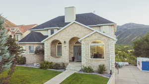 View of front facade featuring a mountain view and a front lawn