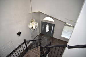 Entrance foyer featuring dark hardwood / wood-style floors, a high ceiling, and a chandelier