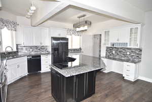 Kitchen with black appliances, a center island, sink, and tasteful backsplash