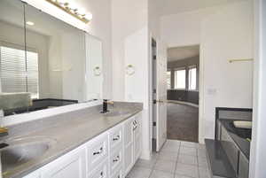 Bathroom featuring tile patterned floors, vanity, and a bathtub