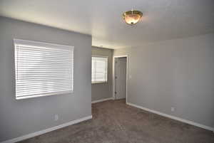 Unfurnished room with dark colored carpet