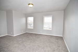 Carpeted empty room with a textured ceiling