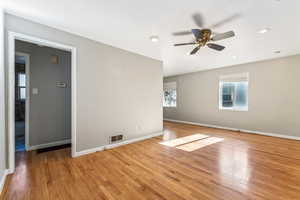 Empty room with ceiling fan and light hardwood / wood-style flooring