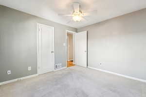 Empty room featuring ceiling fan and light colored carpet