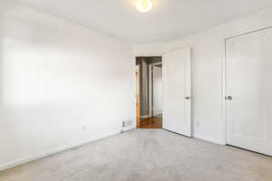 Unfurnished bedroom featuring light carpet