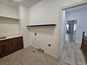 Laundry area with light tile patterned flooring, hookup for a washing machine, and hookup for an electric dryer