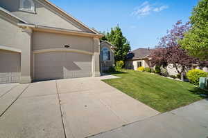 View of front of property featuring a front lawn and a garage