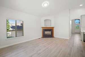 Unfurnished living room featuring light wood-type flooring and a tile fireplace