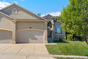 View of front of house featuring a garage and a front yard