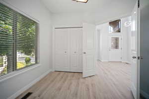 Unfurnished bedroom featuring light wood-type flooring and a closet