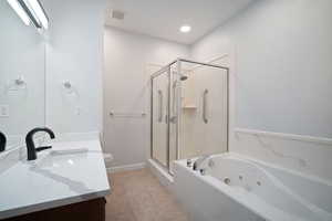 Full bathroom with plus walk in shower, tile patterned flooring, toilet, and vanity