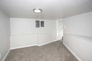 Spare room with a textured ceiling and carpet