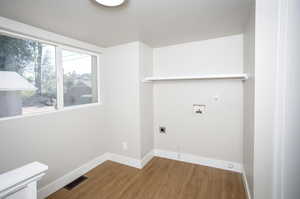 Clothes washing area featuring hardwood / wood-style flooring, electric dryer hookup, and hookup for a washing machine