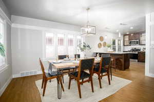 Dining room with a notable chandelier and light hardwood / wood-style flooring