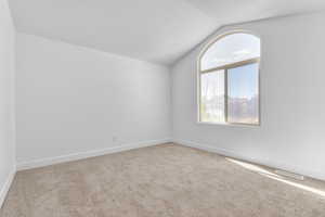 Living room featuring vaulted ceilings and new carpet