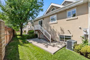 Back of house featuring a patio area, central AC, and a lawn