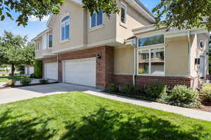 Townhome / multi-family property featuring a front lawn and a garage