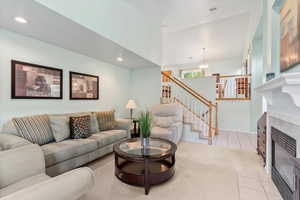 Carpeted living room featuring a tiled fireplace