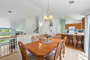 Carpeted dining room featuring vaulted ceiling, and sink