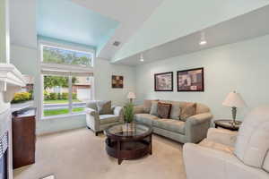 Living room featuring high vaulted ceiling and light colored carpet