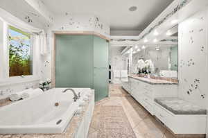 Bathroom with a bathtub, vanity, and tile patterned floors